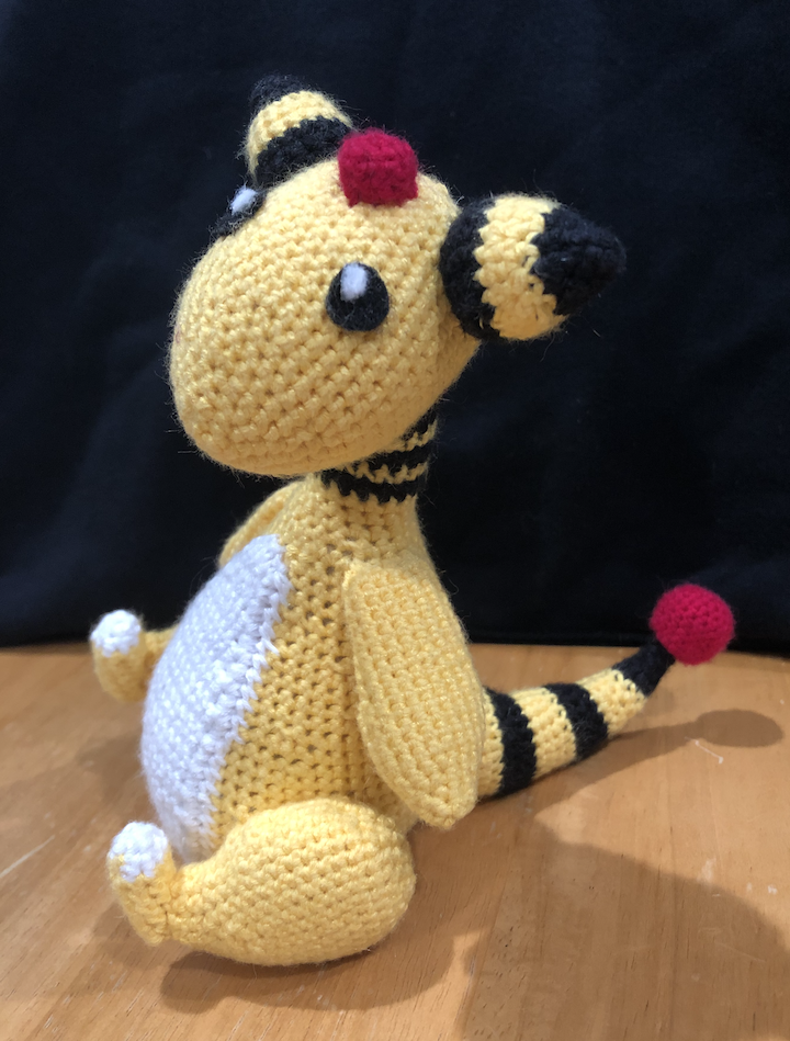 crocheted ampharos sitting and at an angle