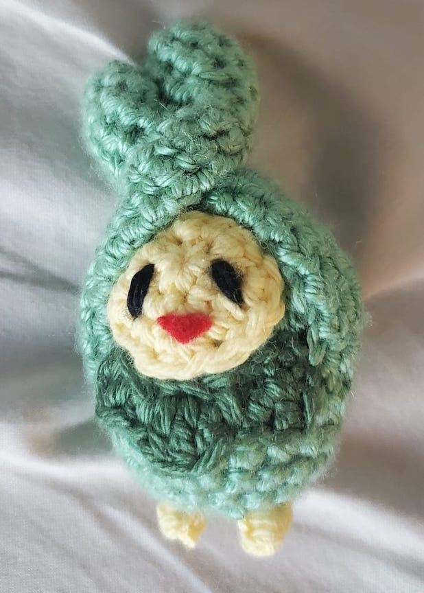 Crochet budew with yarn sewn eyes and a felt mouth