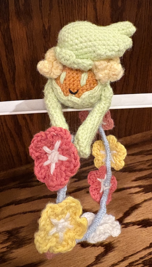 crocheted comfey resting on a bar and looking at you