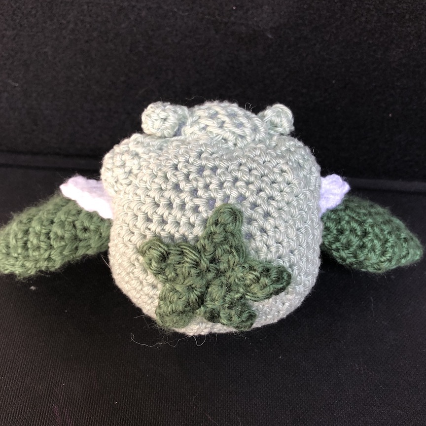 crocheted cottonee from the back, showing the star where a vine would connect