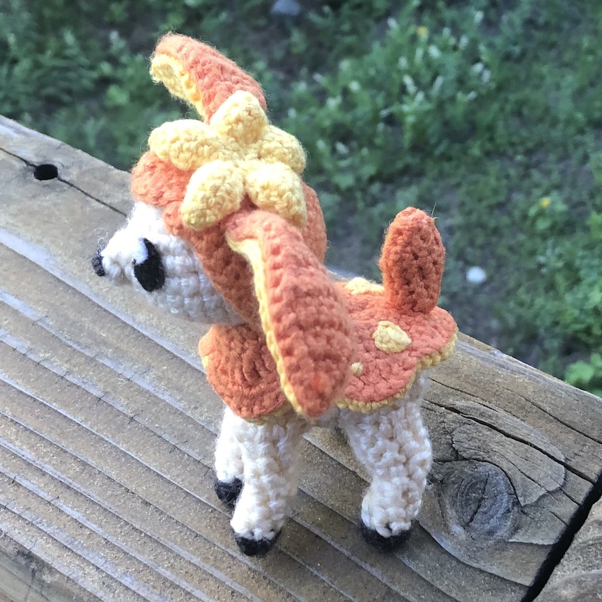 Crocheted deerling in her orange autumn coat, facing to the left