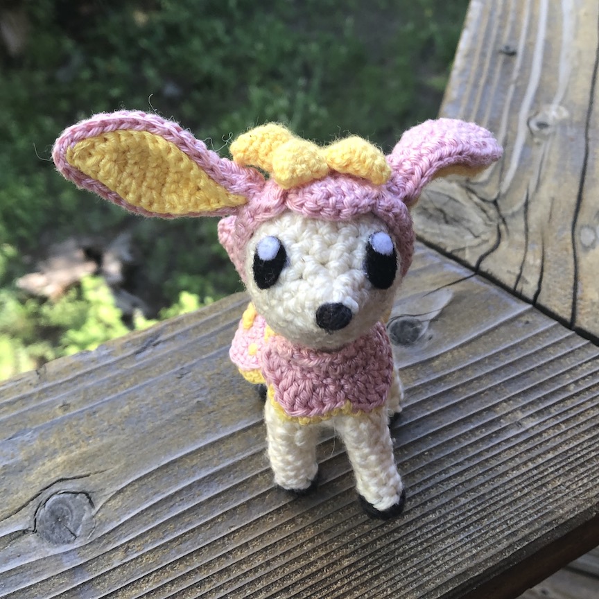 Crocheted deerling in her pink spring coat, facing towards you