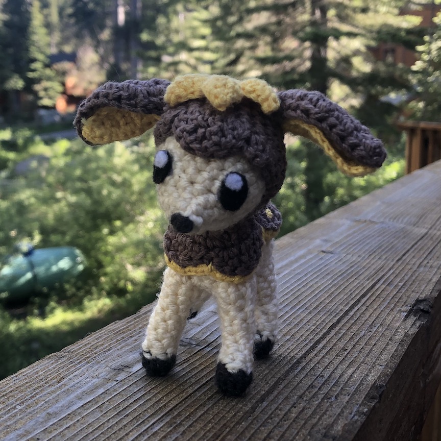 Crocheted deerling in her brown Winter coat, facing towards you