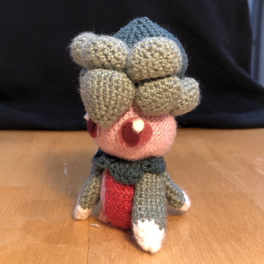 Crochet fomantis from an angle, revealing the leaves it has on its back