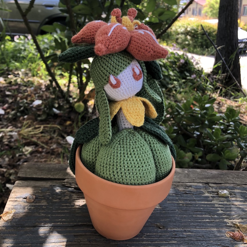 Crocheted lilligant sits in her flower pot in the shade