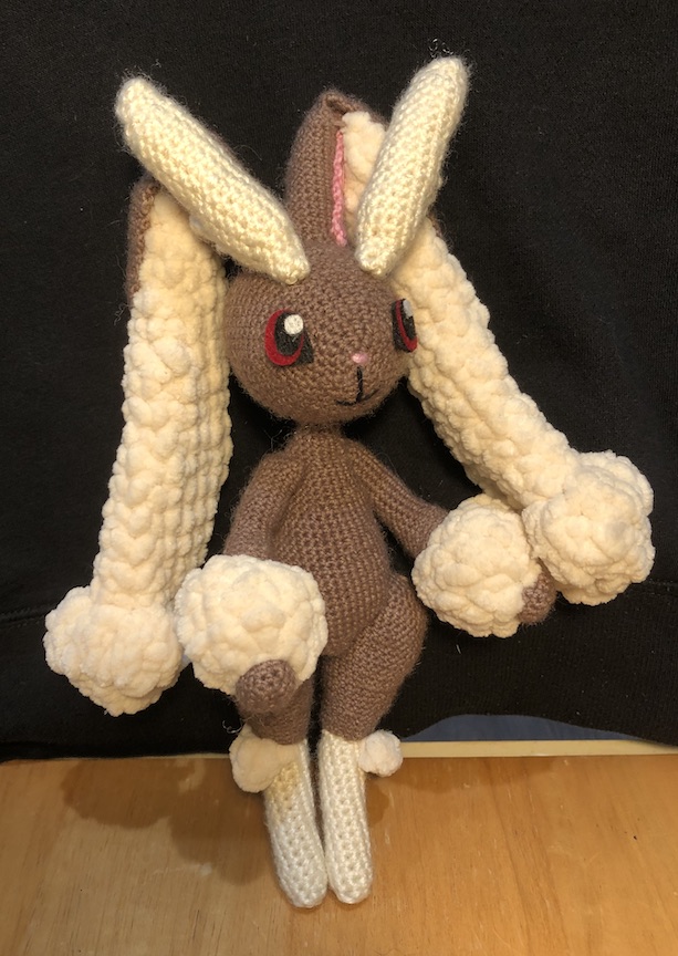 crocheted lopunny standing with her arms at her sides, gazing off into the distance