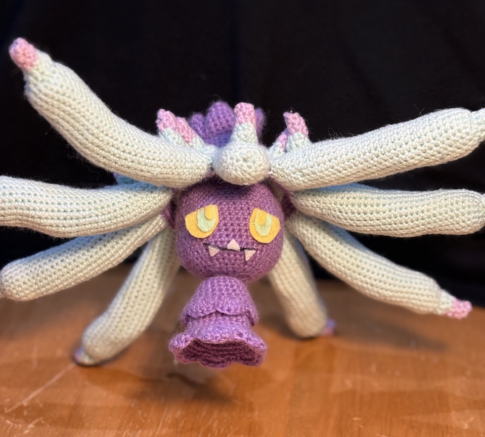 Crochet mareanie with tentacles outstretched in all directions, like she's trying to look as big as possible