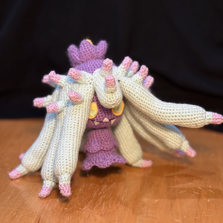 Crochet mareanie at an angle with a few tentacles casually tossed in the air