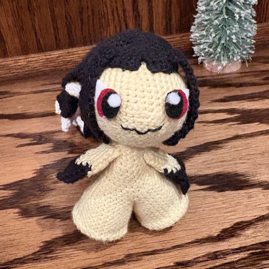 crocheted mawile facing you with her little smile