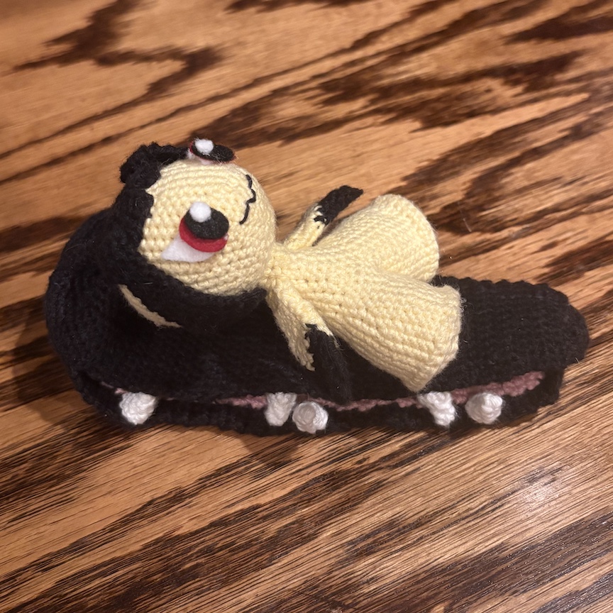 crocheted mawile laying on her ponytail
