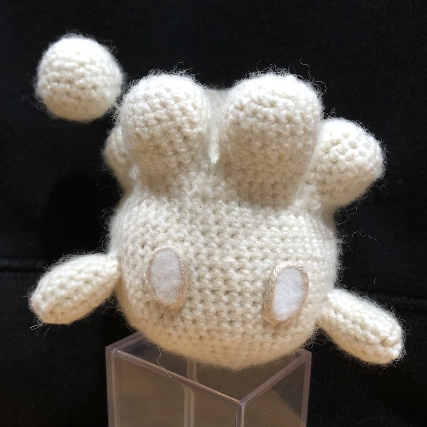crocheted milcery facing you, also on the clear plastic box