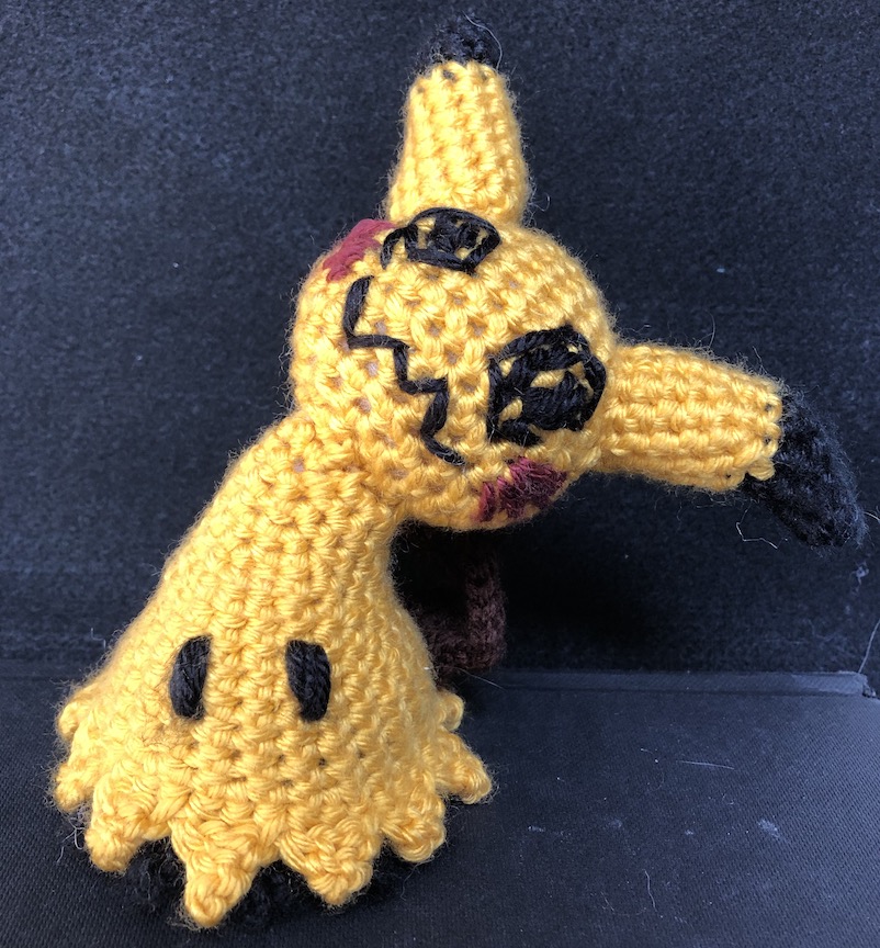 Crocheted mimikyu with rich deep yellow as it's disguise - more reminiscent of pikachu's color palette than the colors typically associated with mimikyu.