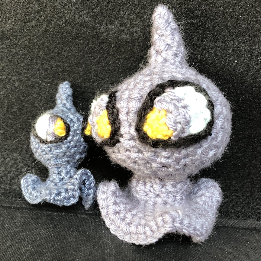 Two crocheted shuppets, one larger and one smaller