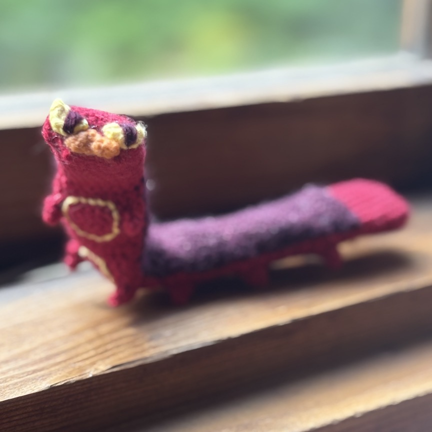 Crocheted sizzlipede with his upper body raised so he can look at you