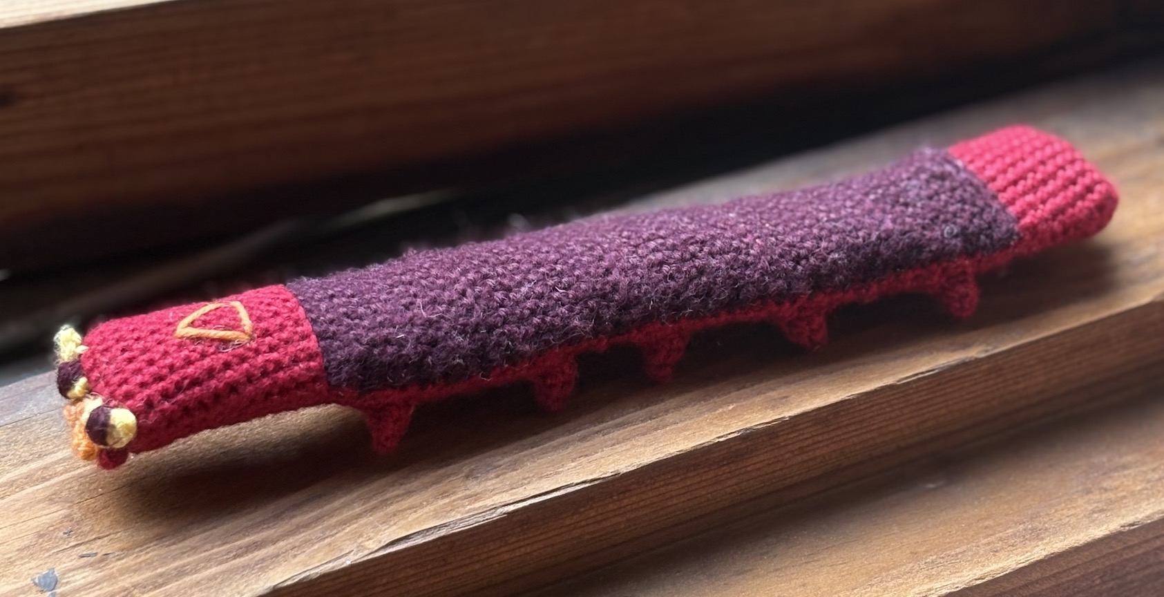 Crocheted sizzlipede flat on the windowsill with all feet down