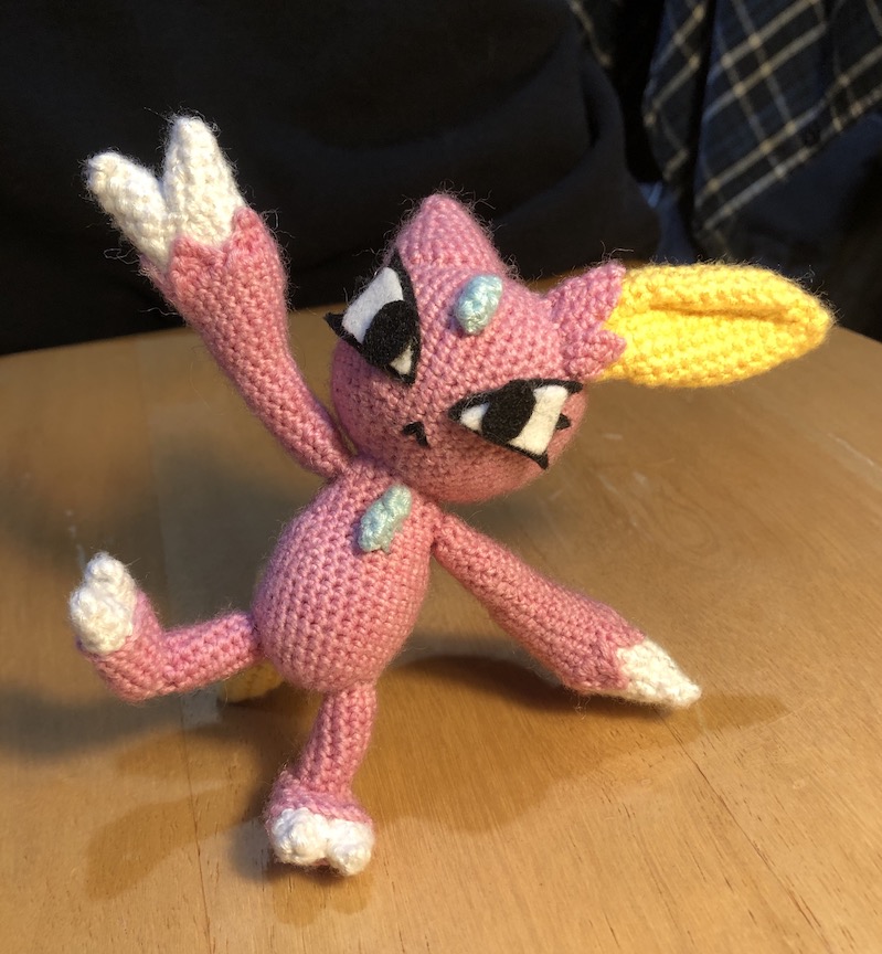 shiny crocheted sneasel striking a silly pose with one arm and one leg in the air