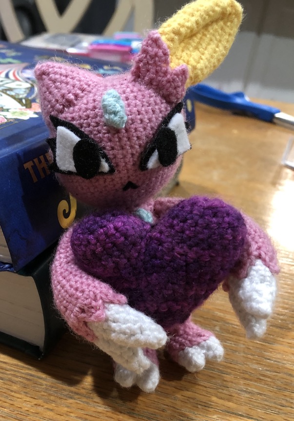 shiny crocheted sneasel hugging a purple crocheted amigurumi heart