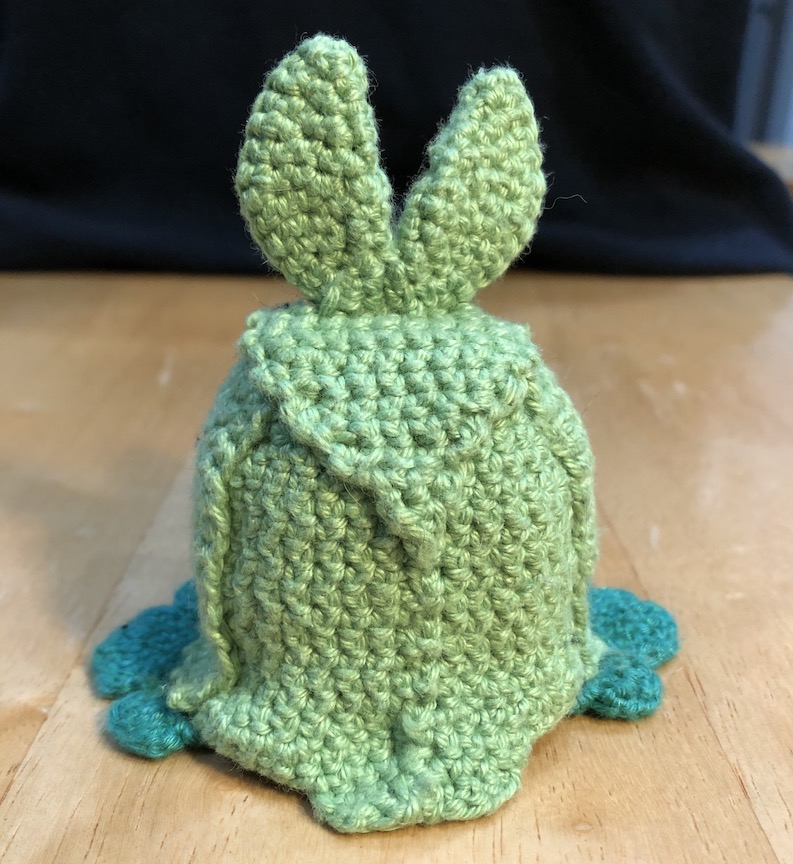 crocheted swadloon from the back, showing off the traingle patterns of her leaf blanket