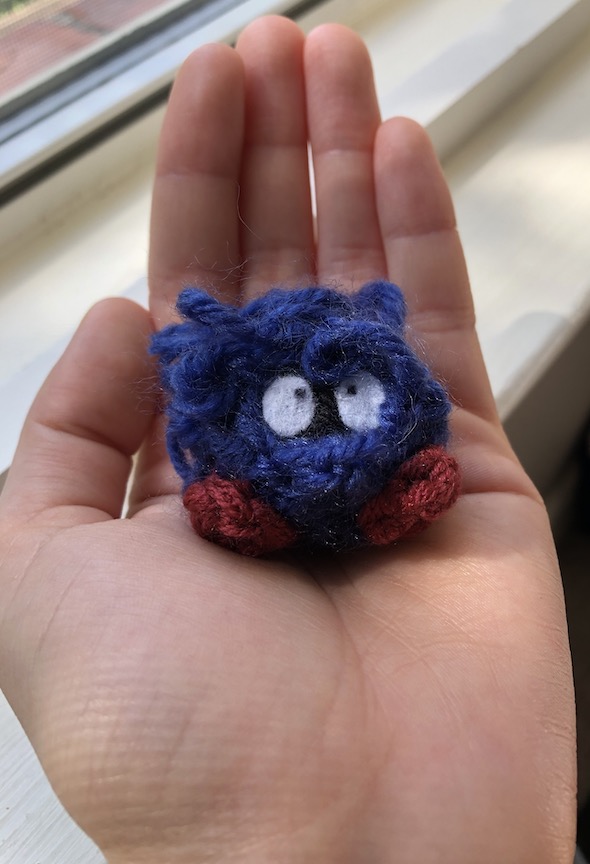 crocheted tangela sitting in the palm of my hand