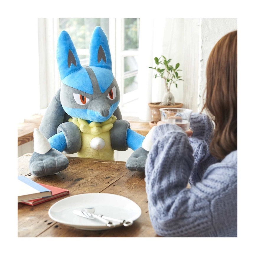 Lucario sitting at a table listening to a woman talking