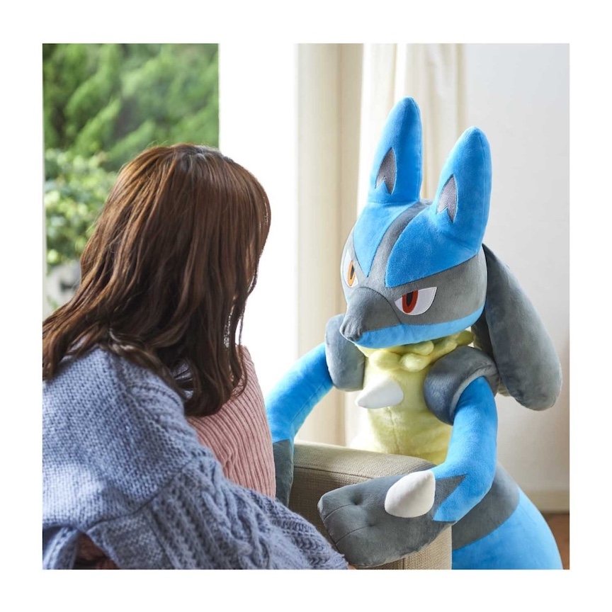Big Lucario listens to a woman sitting on a couch