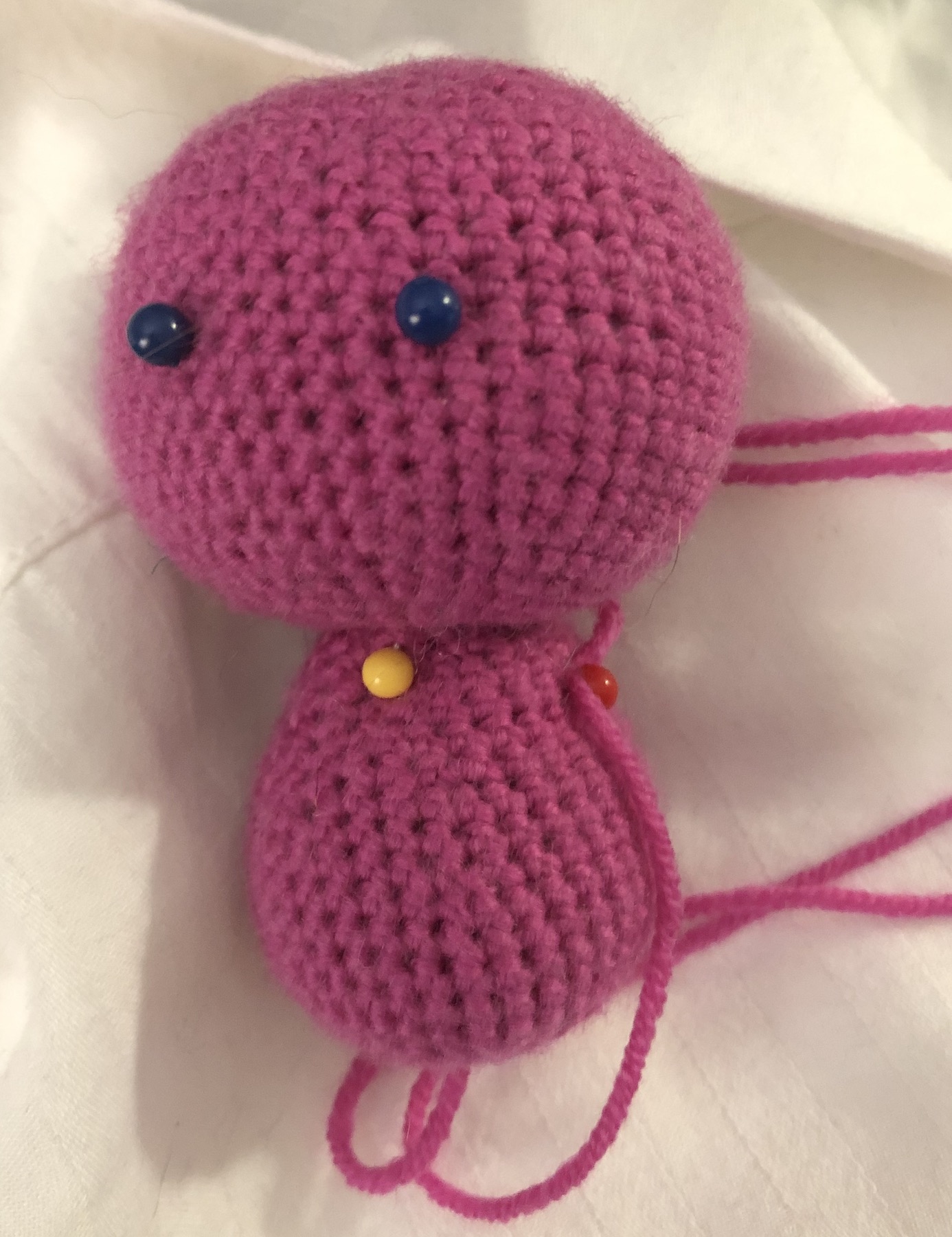 Hot pink crocheted head and body only, with pins in place of eyes
