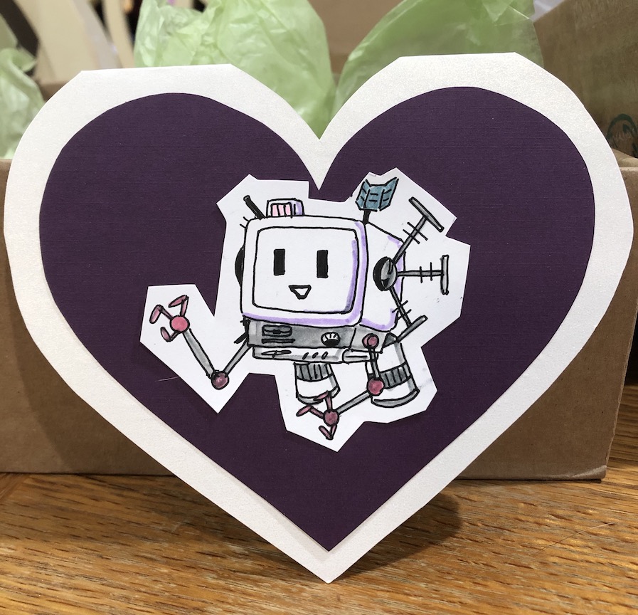 A heart shaped paper Valentine card with a shiny off white border and a deep purple heart at the center. There's a cutout of a hand-drawn little computer robot - the character SCOUT from the game Murder by Numbers